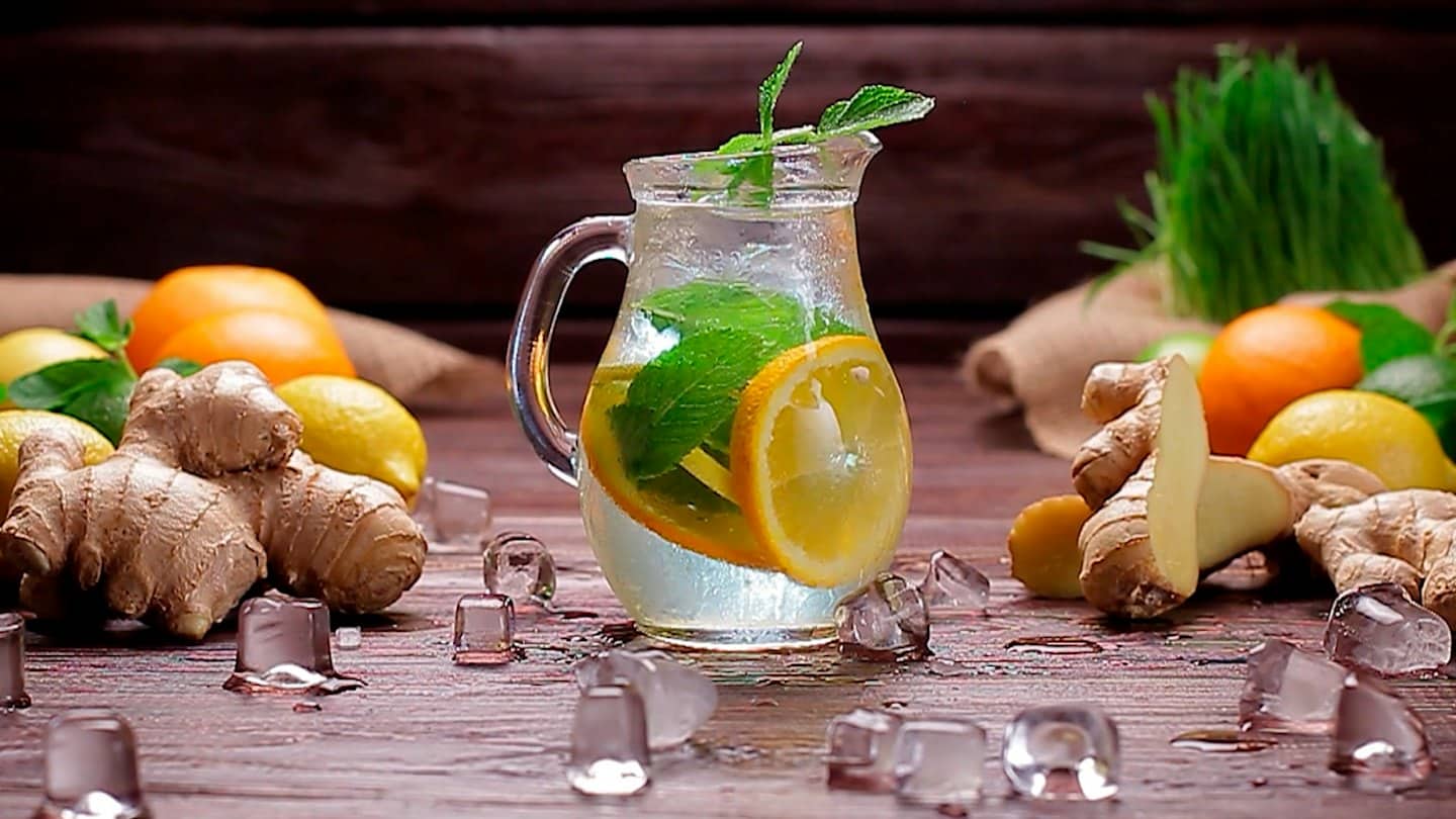 Pitcher of lemon mint ginger water on a rustic wooden table.