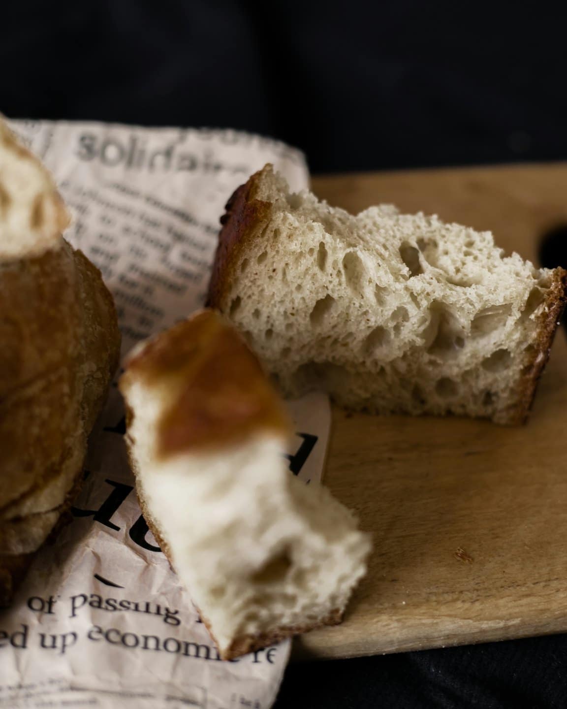 Crusty sourdough loaf on a wooden cutting board.